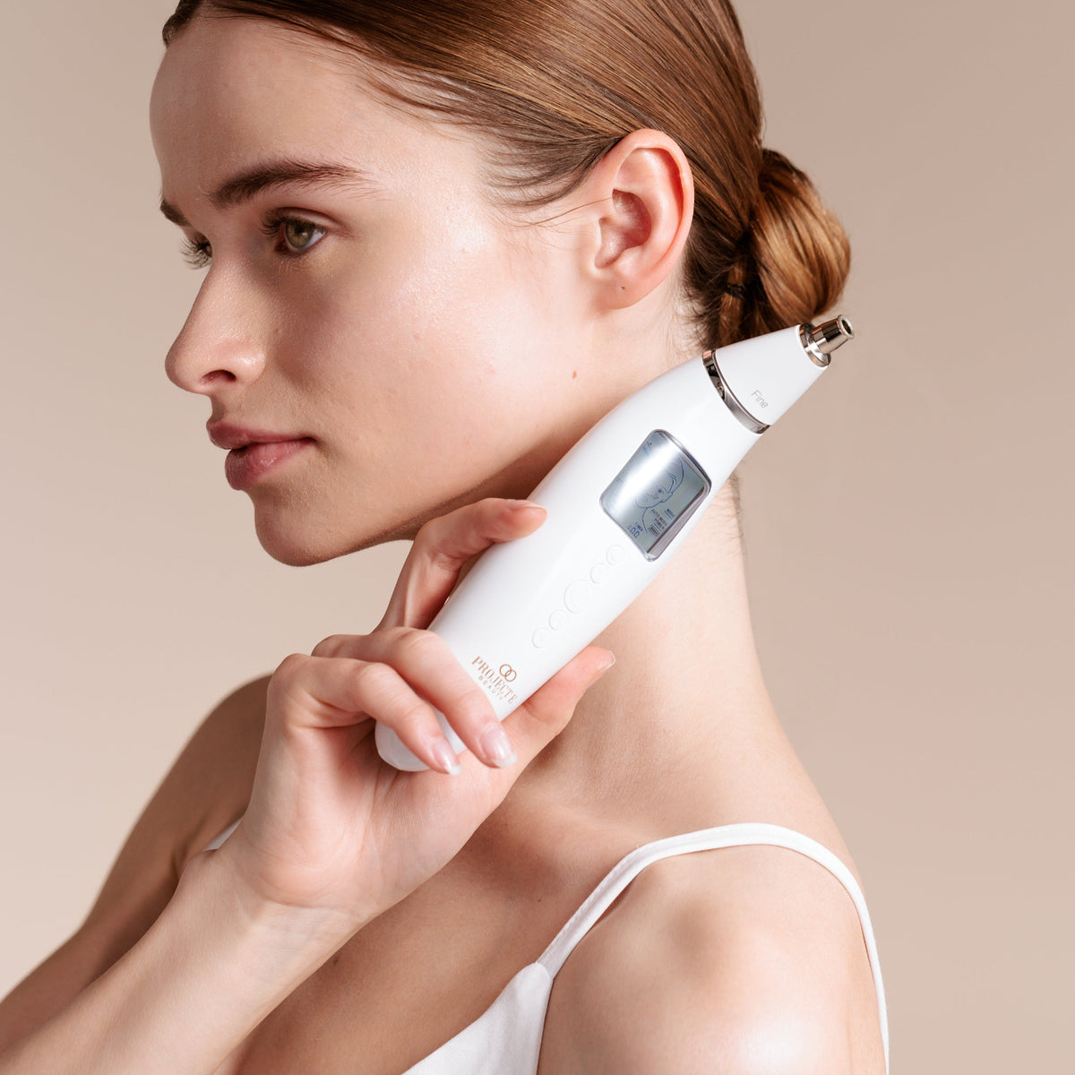 Model featuring Reinvo microdermabrasion device for radiant skin.