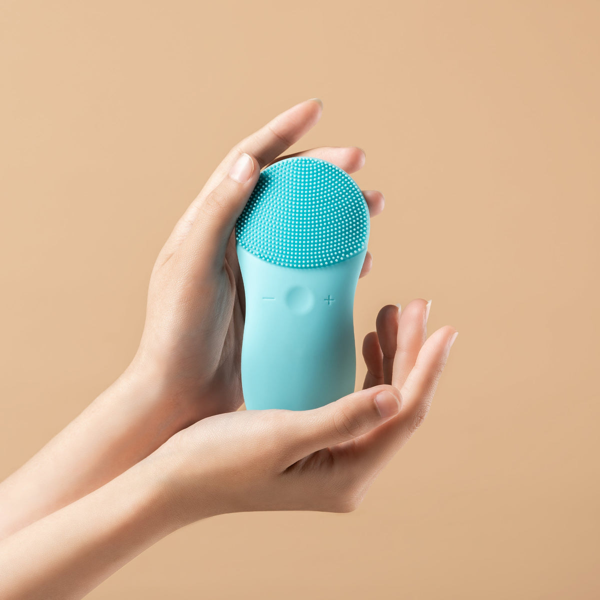 Hand holding CLEO+ silicone sonic facial cleansing brush