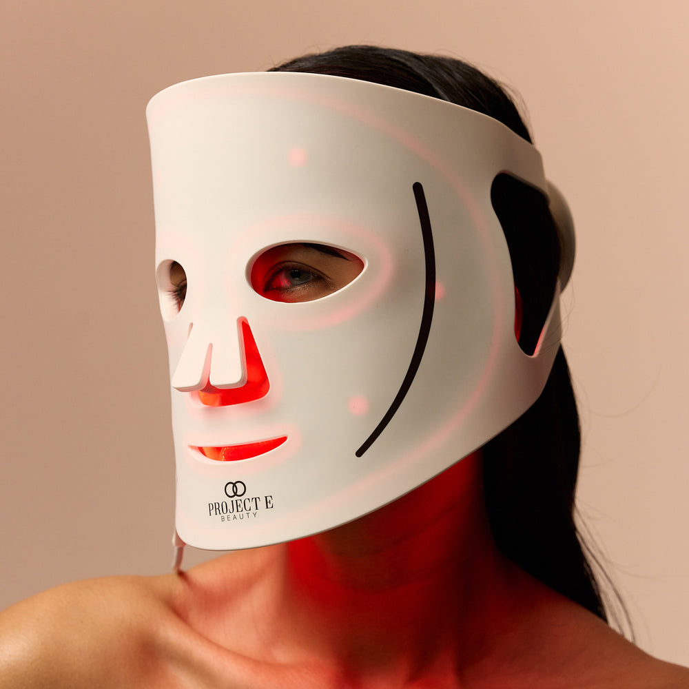Gros plan d’une femme portant LumaLux Face LED avec lumière rouge visible à l’intérieur